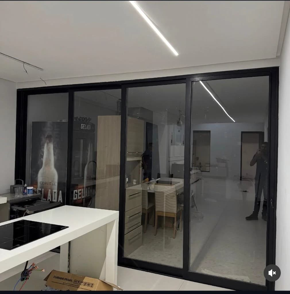 Guarda-corpo de vidro instalado em ambiente integrado com acabamento em alumínio